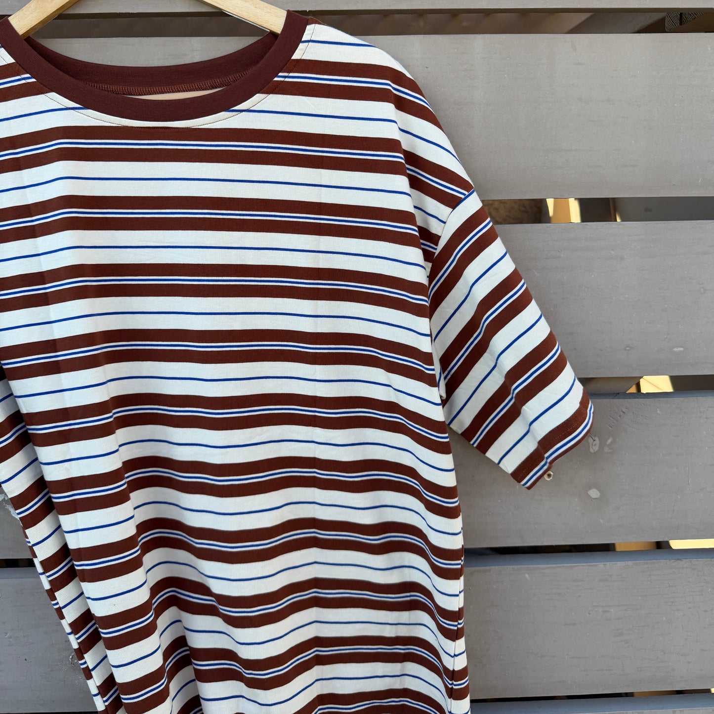 Striped shirt on a hanger against a wooden background