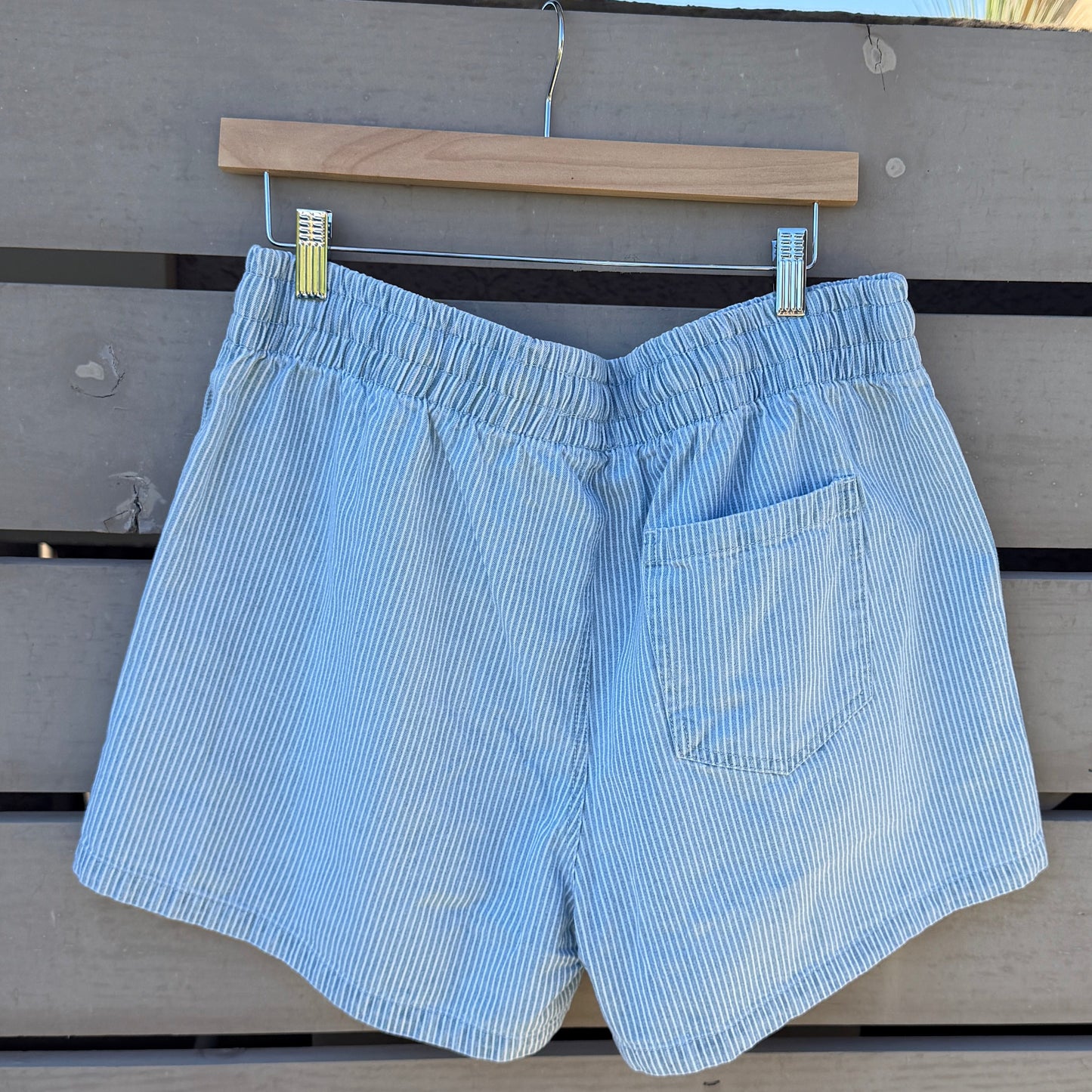 Light blue shorts hanging on a wooden slat wall