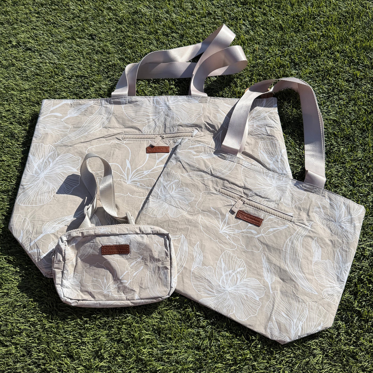 Floral-patterned tote bag and pouch on grass