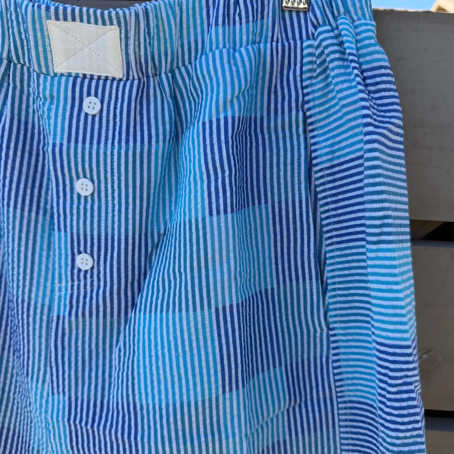 Blue and white striped shorts hanging on a clothesline.