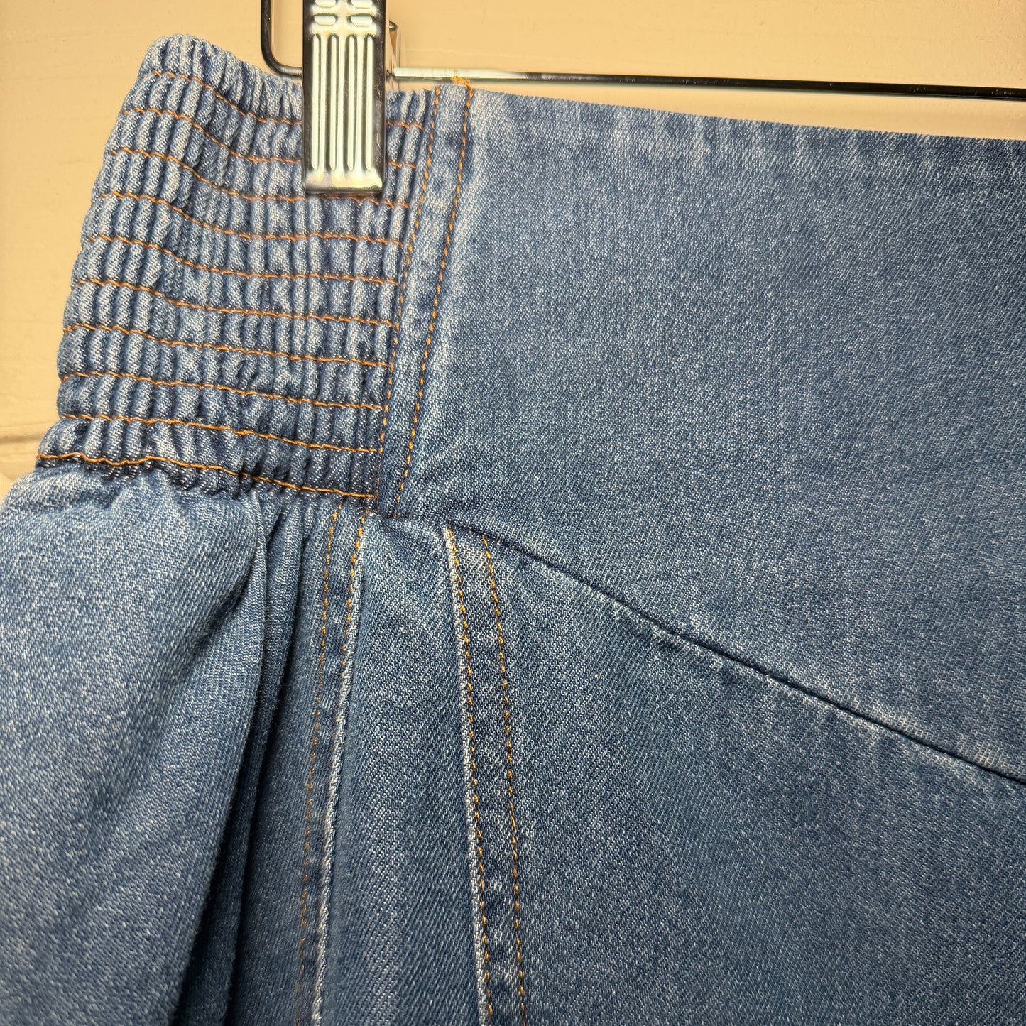 Close-up of blue jeans with a zipper on a beige background