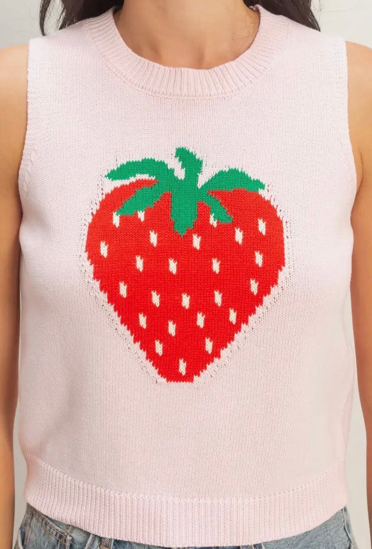 Pink sleeveless sweater with a strawberry design on a plain background