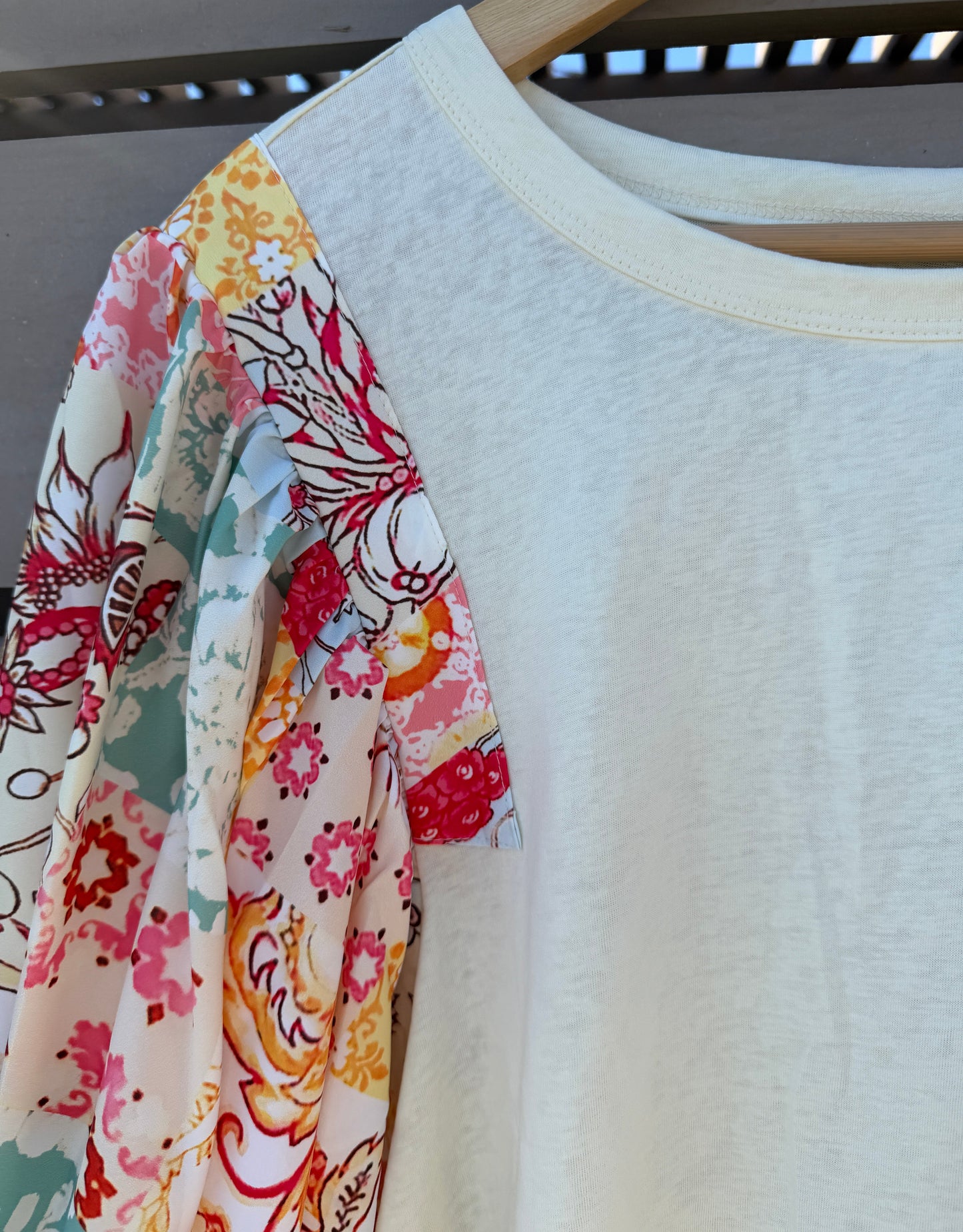 Floral-patterned fabric draped over a plain white shirt on a hanger.