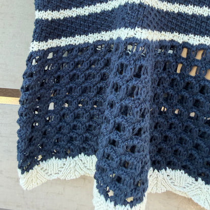 Blue and white crocheted tank on a wooden surface