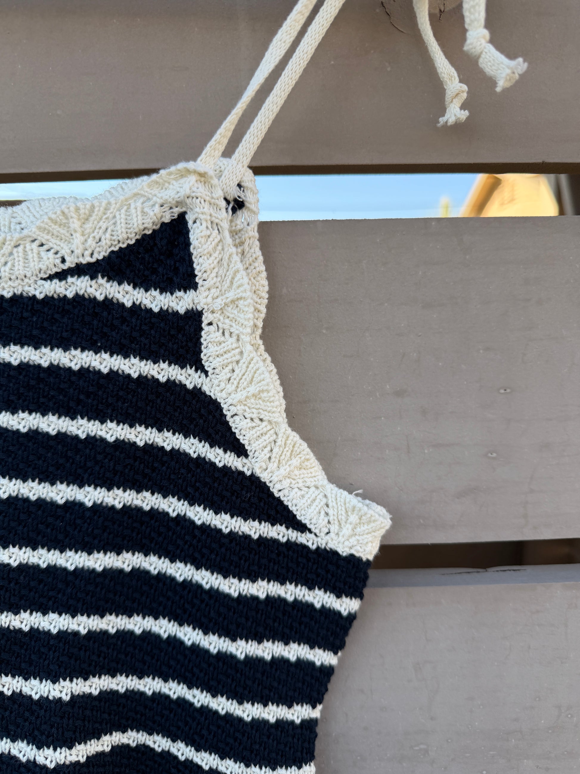 Nautical-style tank with navy and white stripes hanging on a wooden surface