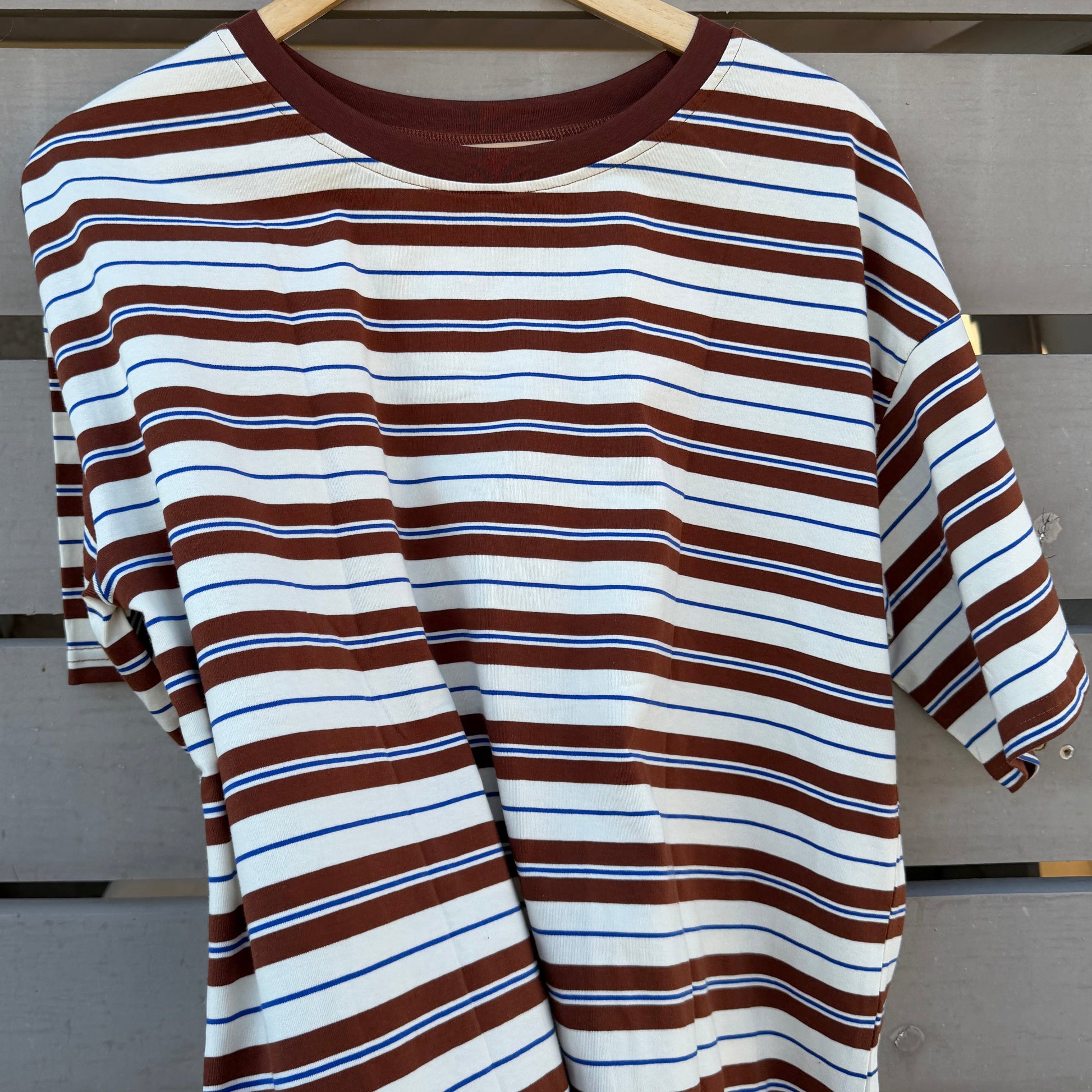 Striped shirt on a hanger against a wooden background