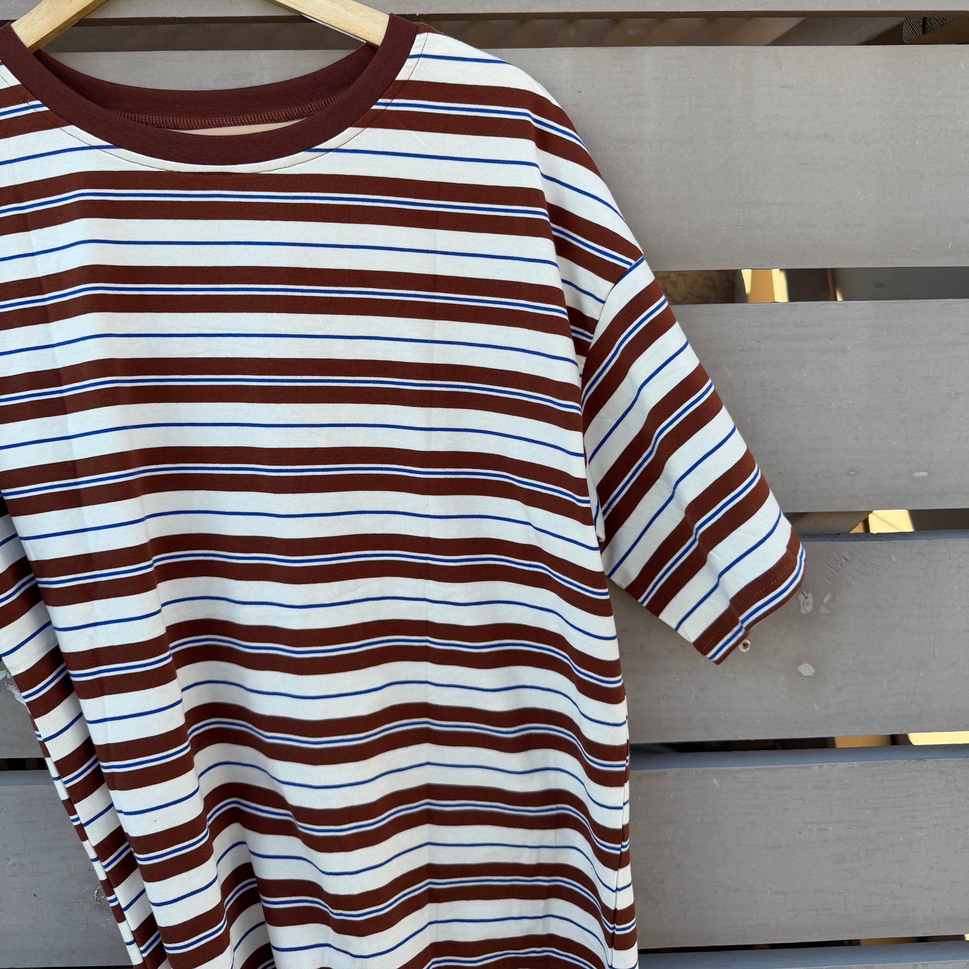Striped shirt on a hanger against a wooden background