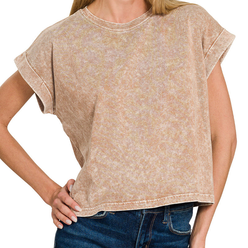 Woman wearing a brown patterned shirt and blue jeans on a white background