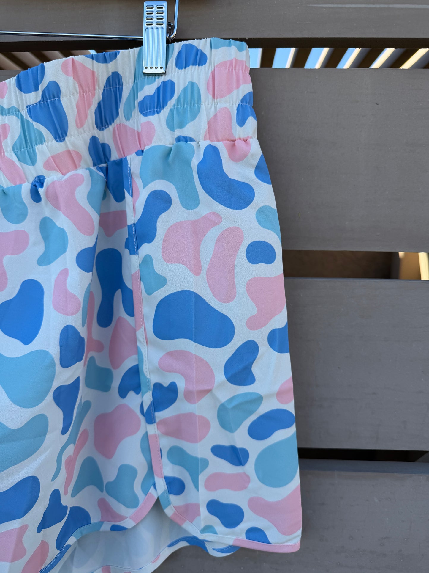 Folded fabric with pink and blue abstract pattern on a wooden surface