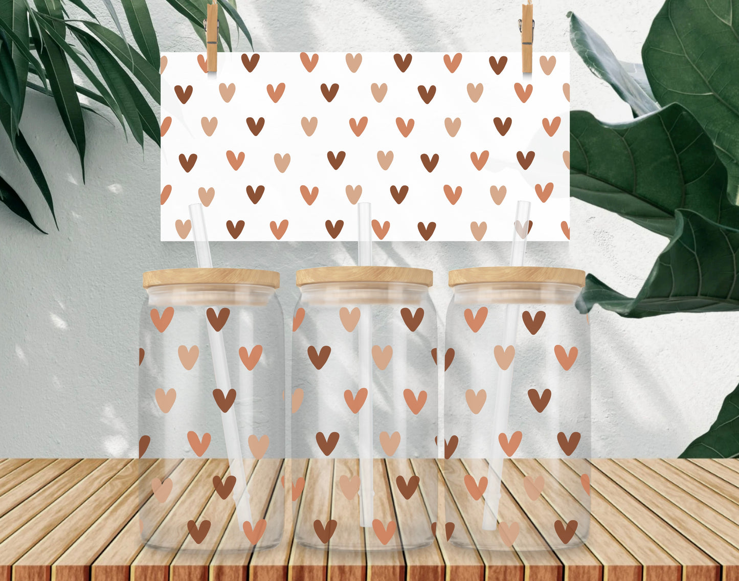 Three glass jars with wooden lids on a wooden surface, each featuring a heart pattern.