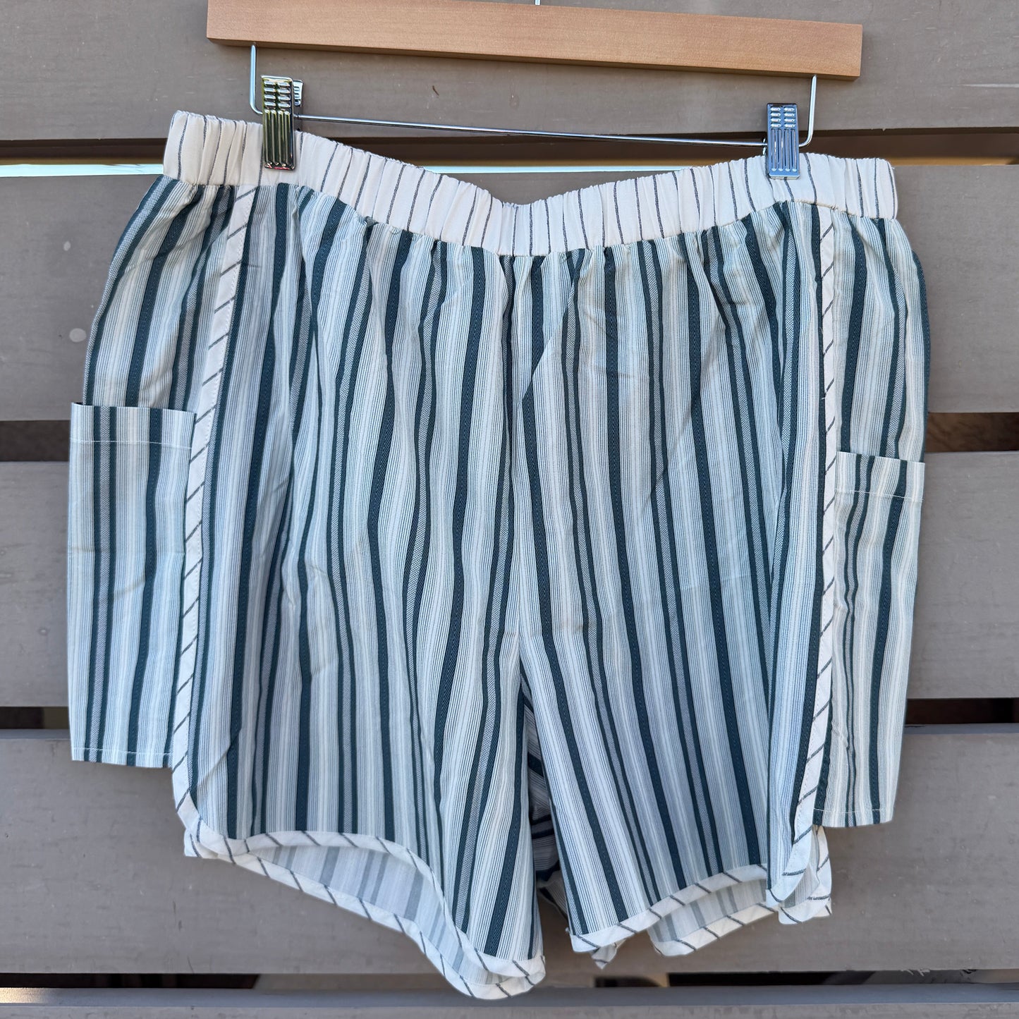 Striped shorts hanging on a wooden surface with a wooden frame in the background