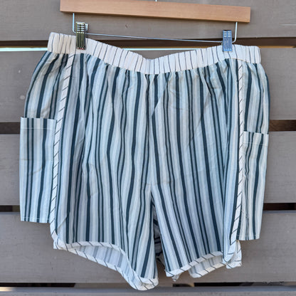 Striped shorts hanging on a wooden surface with a wooden frame in the background