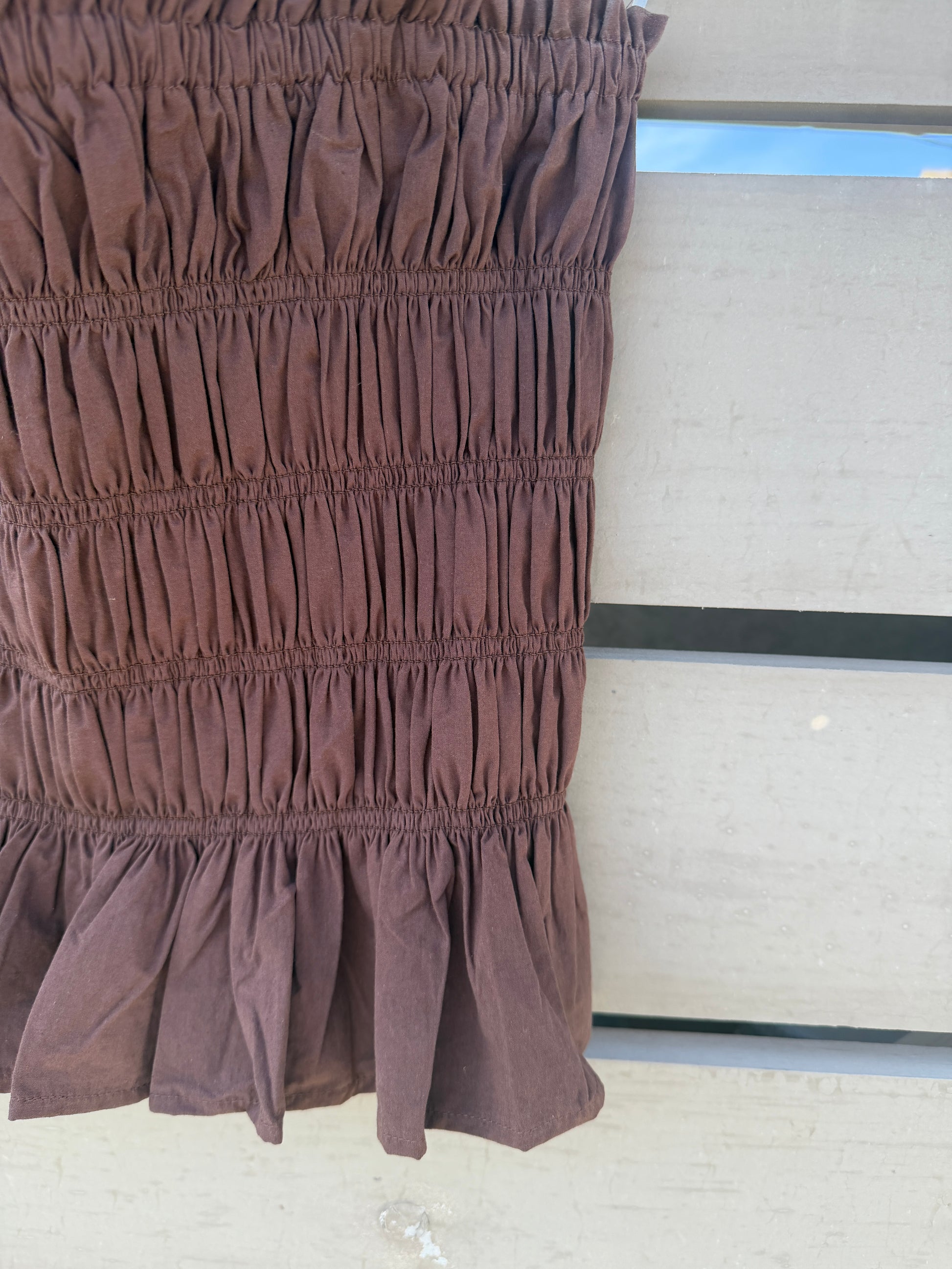 Brown ruffled fabric against a neutral background