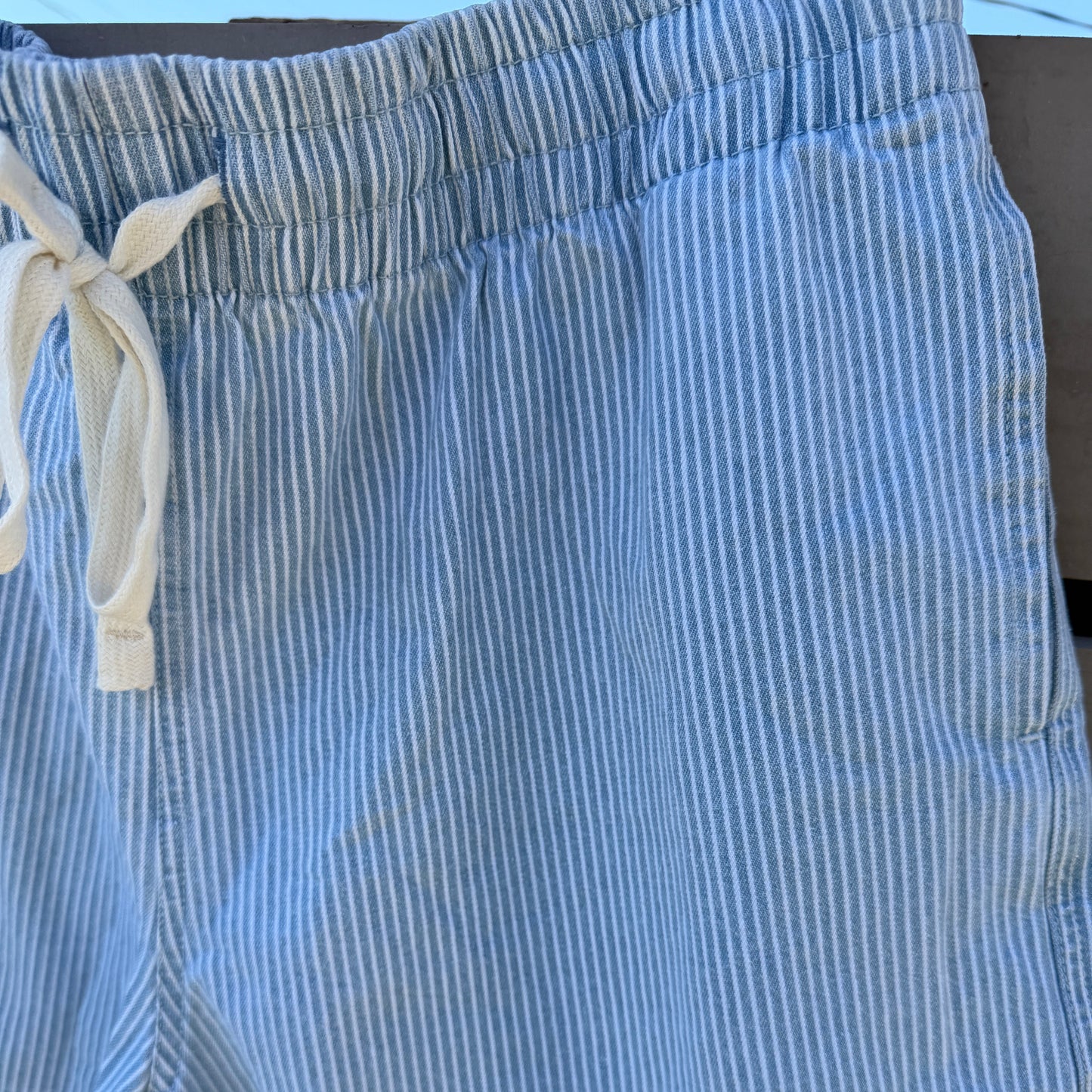 Blue and white striped shorts with a drawstring on a neutral background