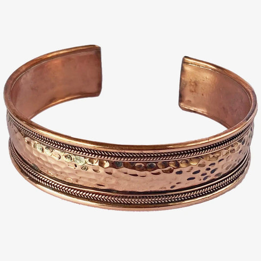 Copper bracelet with textured design on a white background