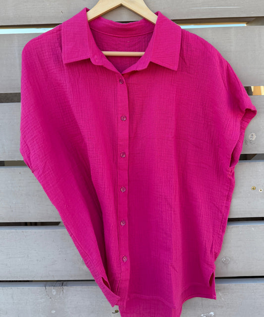 Pink shirt on a wooden hanger against a wooden background
