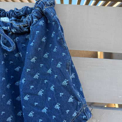 Blue patterned pants hanging on a metal rack.