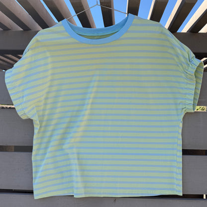 Striped shirt on a wooden surface with a blue sky background