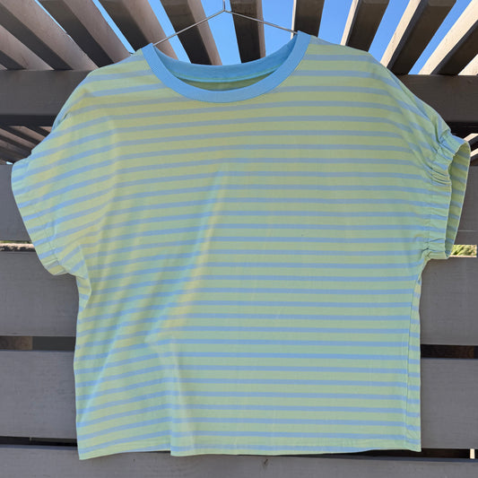 Striped shirt on a wooden surface with a blue sky background