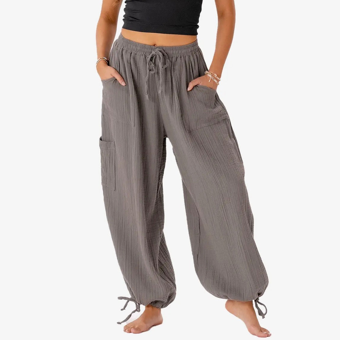 Person wearing gray wide-leg pants with a white background