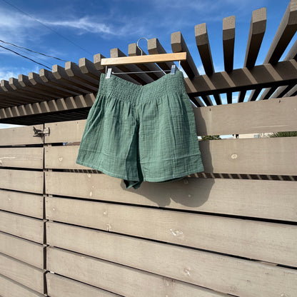 Green shirt hanging on a clothesline against a blue sky