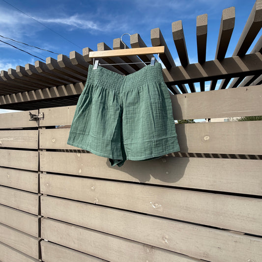 Green shirt hanging on a clothesline against a blue sky