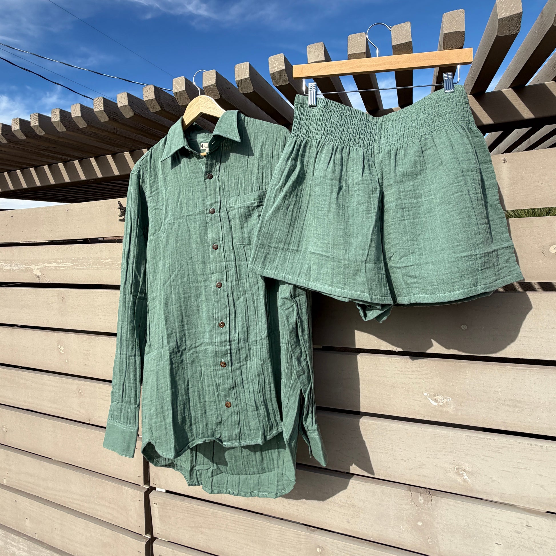 Green fabric on a wooden deck with blue sky in the background