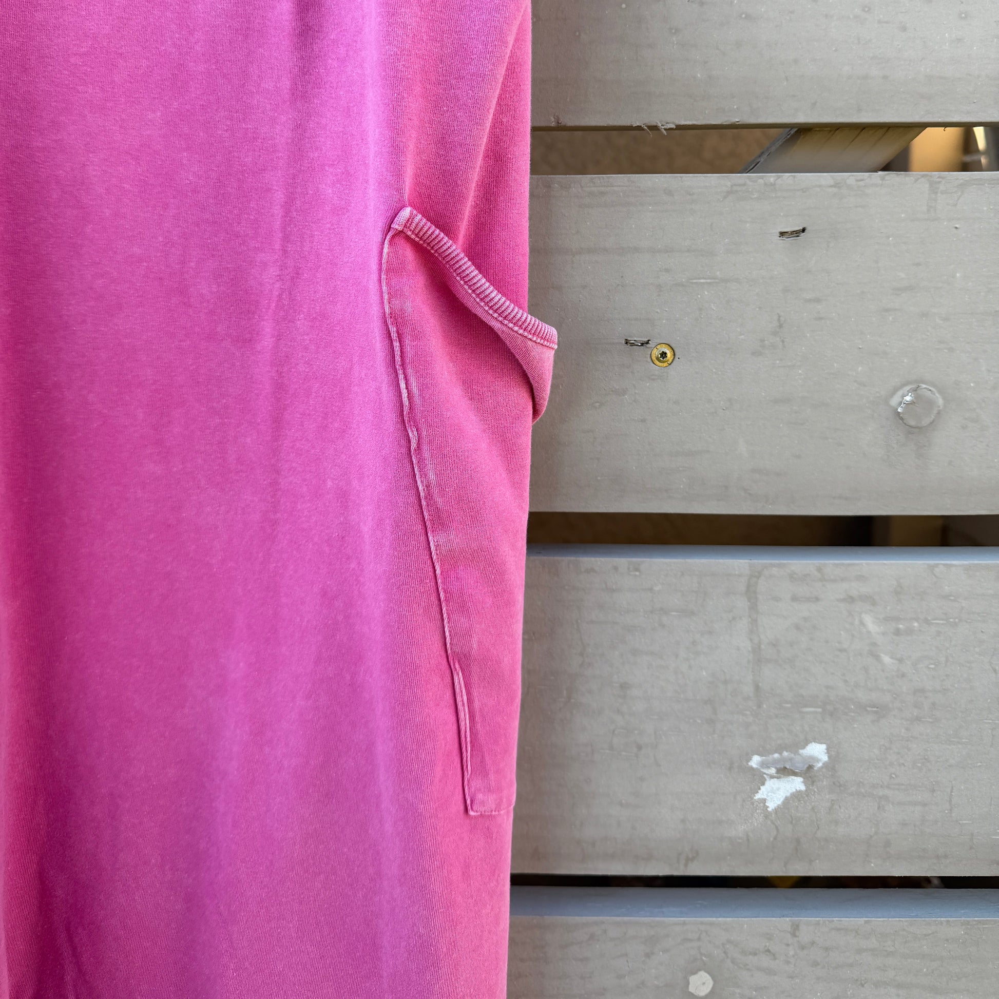 Close-up of a pink jumpsuit with a wooden background