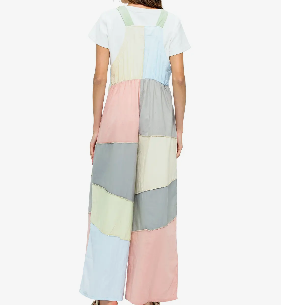 Woman wearing a long, multicolored overalls with a white background