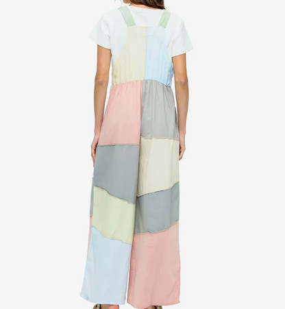 Woman wearing a long, multicolored overalls with a white background