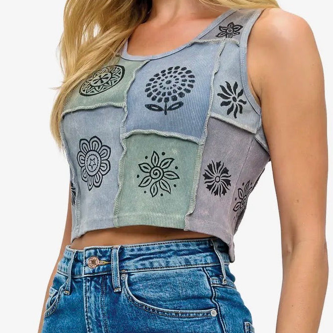 Person wearing a patchwork crop top and blue jeans on a white background