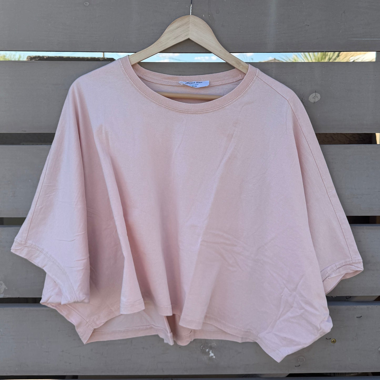 Pink tshirt hanging on a wooden hanger