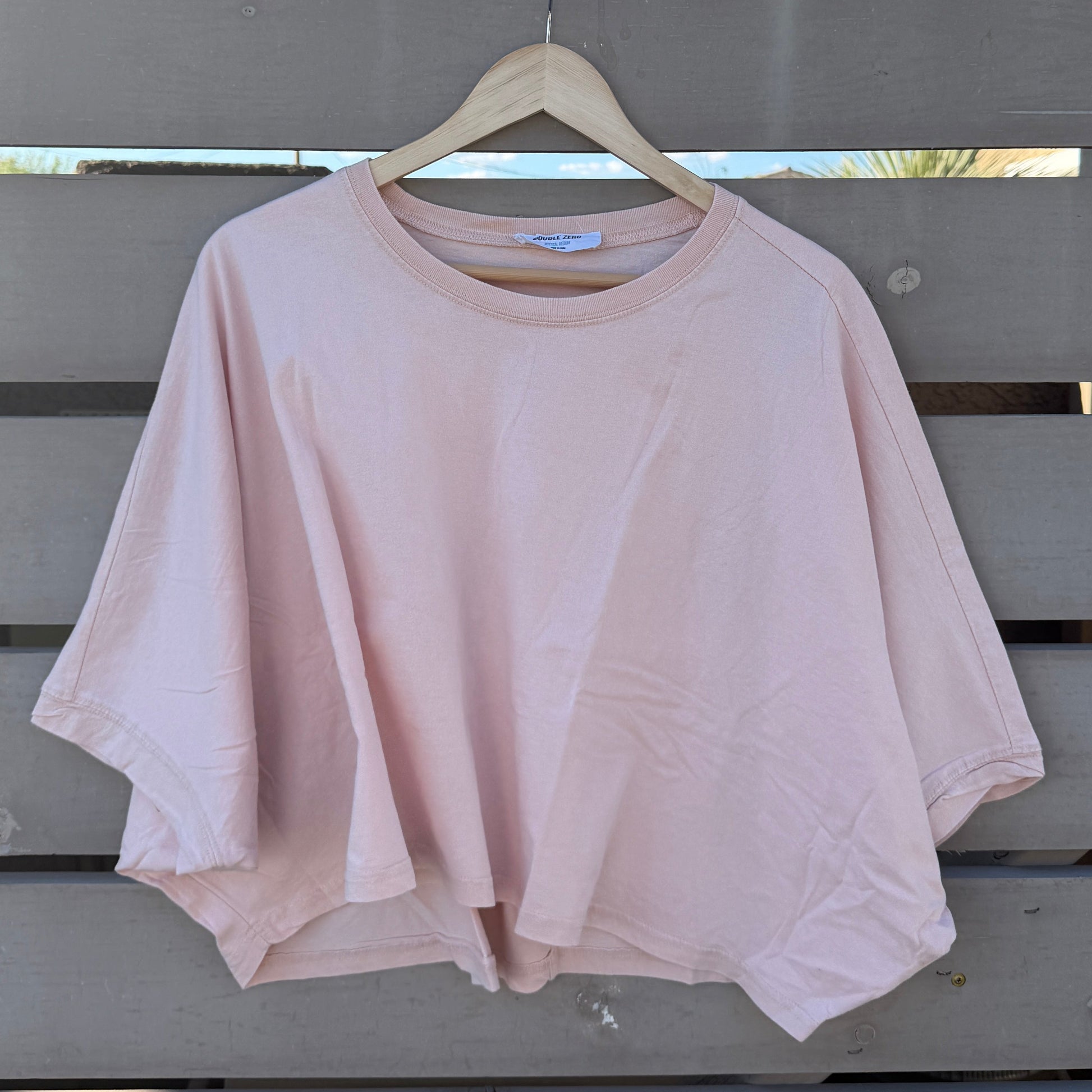 Pink tshirt hanging on a wooden hanger