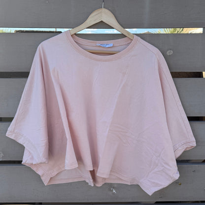 Pink tshirt hanging on a wooden hanger