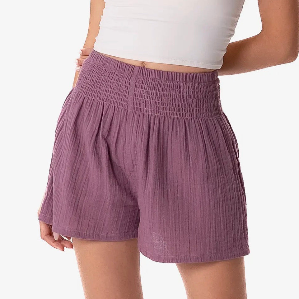 Purple shorts worn by a person on a white background