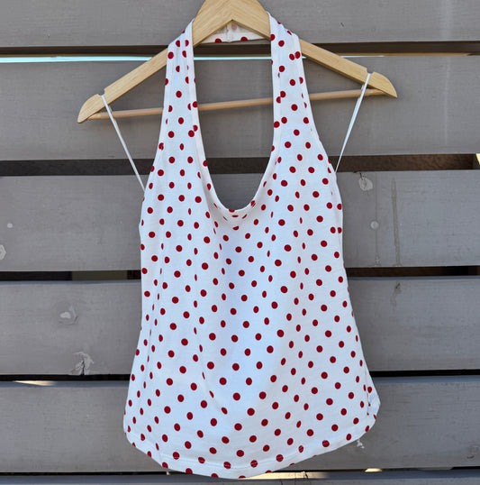 White tank top with red polka dots on a wooden background