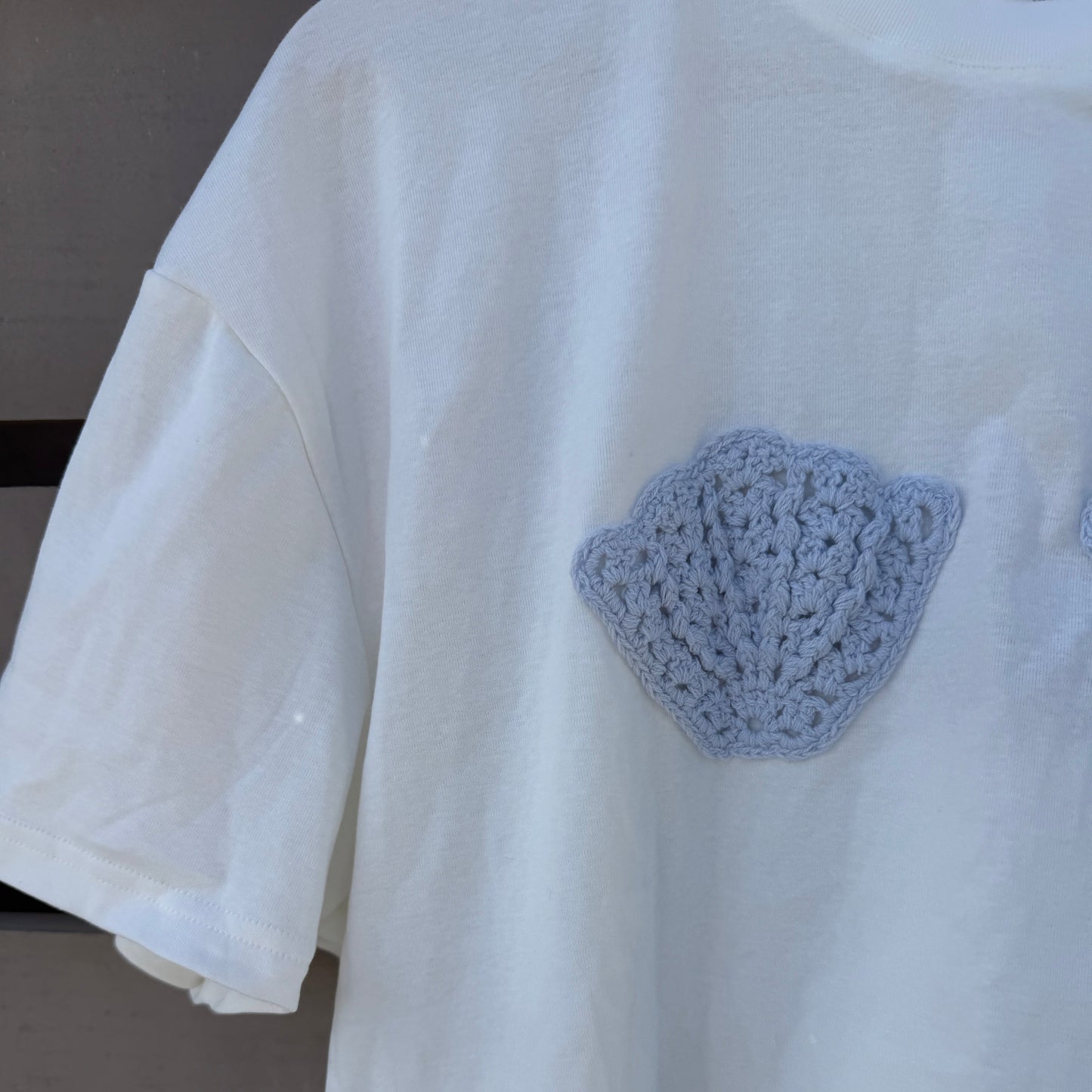 White shirt with a blue shell on a neutral background 