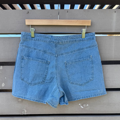 Blue denim shorts hanging on a wooden rack against a wooden wall.