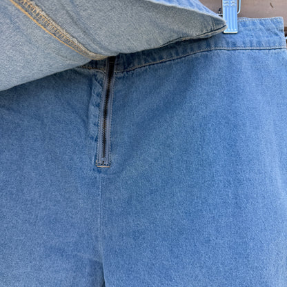 Close-up of blue denim shorts with a zipper on a wooden surface