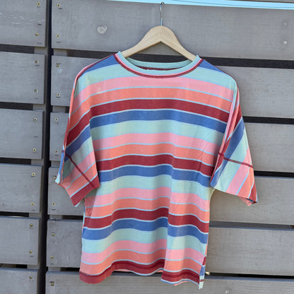 Striped shirt hanging on a wooden wall with a blue sky background