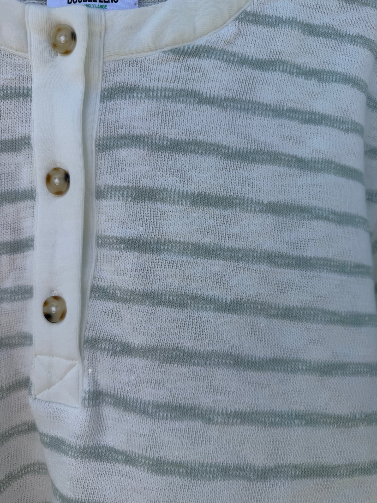 Close-up of a striped fabric with buttons on a garment