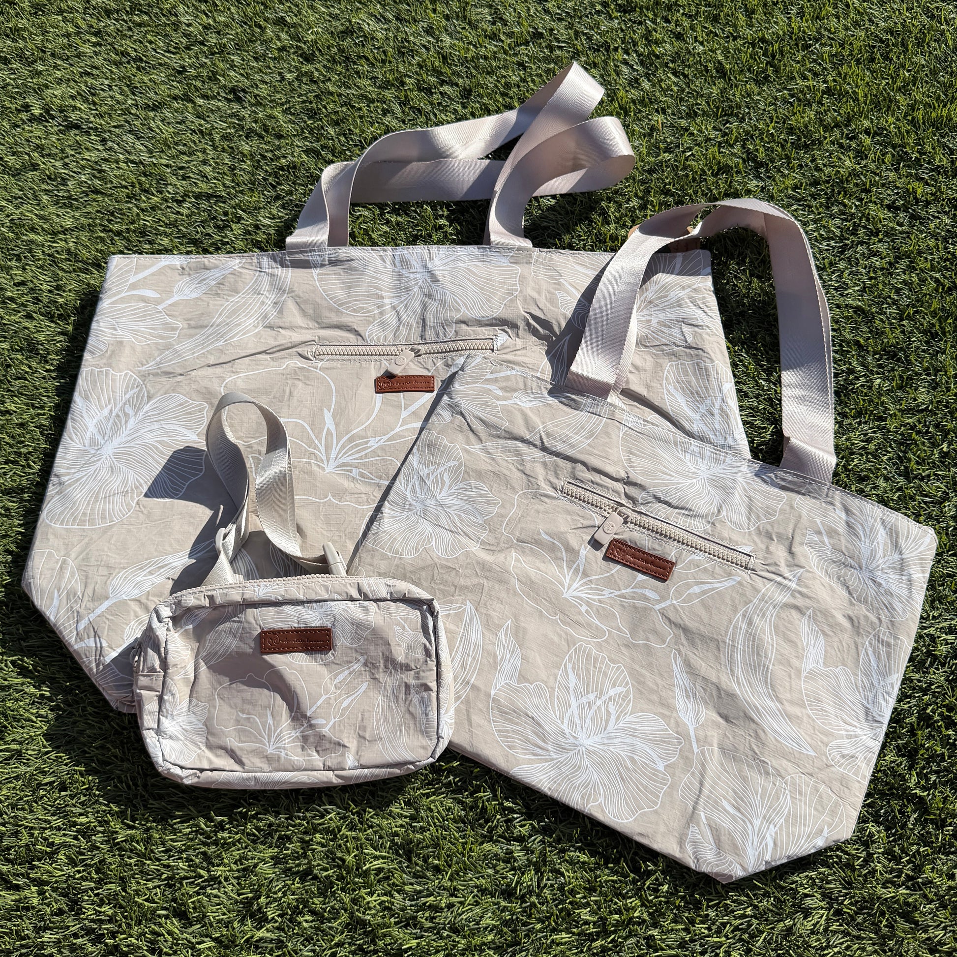 Floral-patterned tote bag and pouch on grass