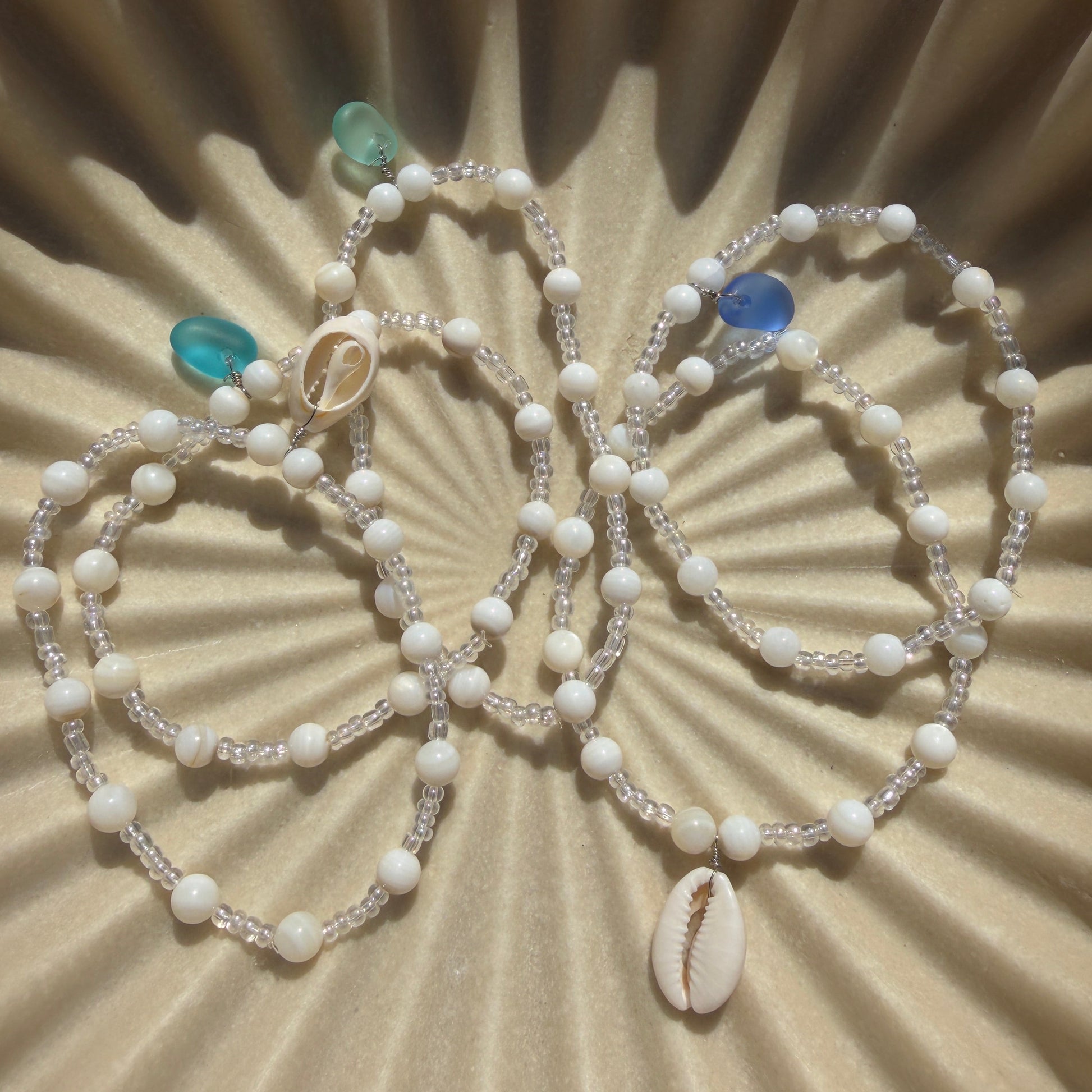 Beaded necklace with turquoise stones on a textured beige surface