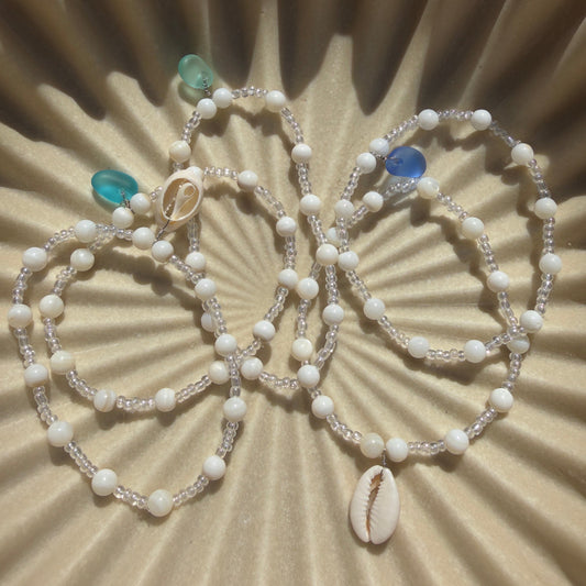 Beaded necklace with turquoise stones on a textured beige surface