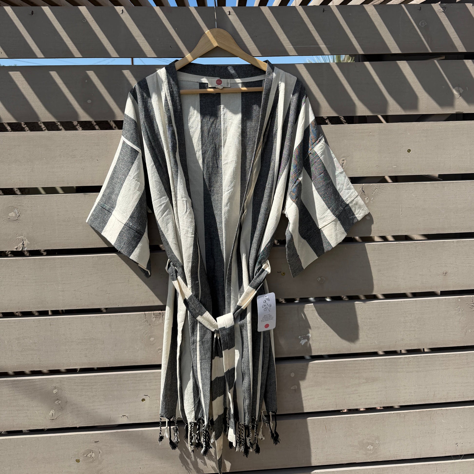 Black and white striped fabric draped over a wooden surface with a blue sky background