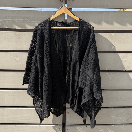 Black fabric draped over a metal gate with a blurred background