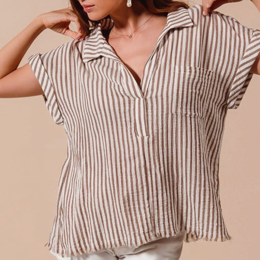 Woman wearing a brown and white striped shirt against a beige background