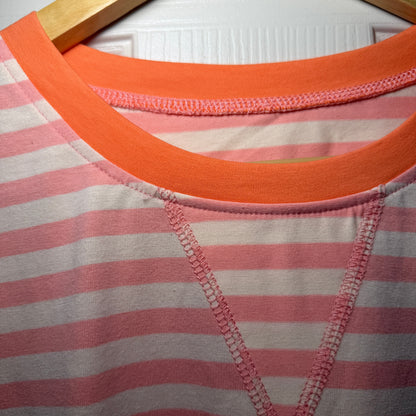 Close-up of a pink and orange striped garment with a wooden frame.