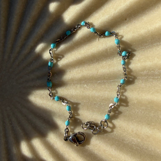 Bracelet with turquoise beads on a textured beige surface