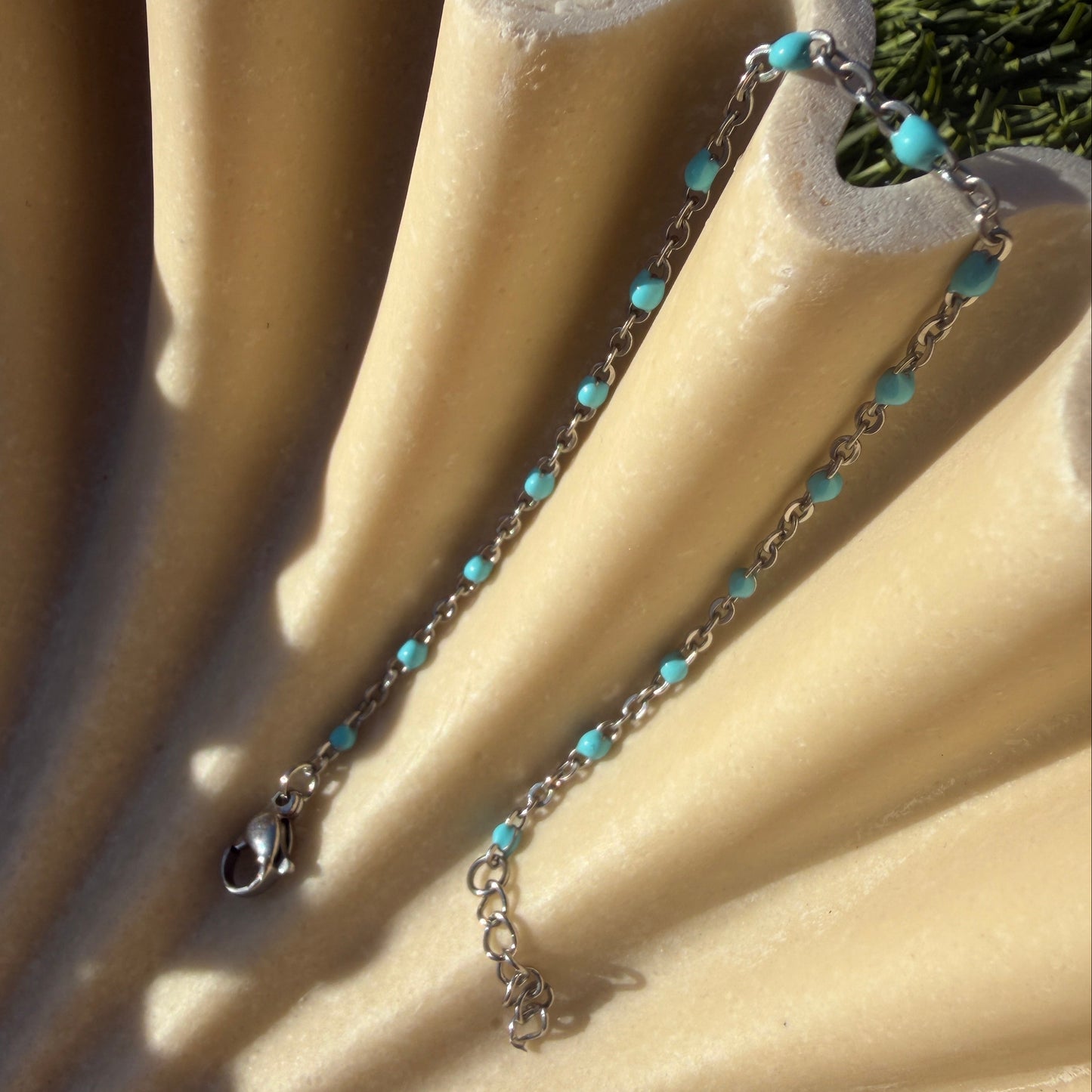 Necklace with turquoise beads on a beige fabric background
